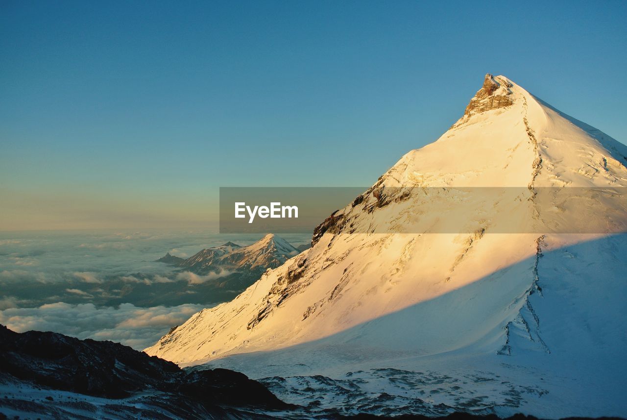 Scenic view of snowcapped mountains against clear blue sky