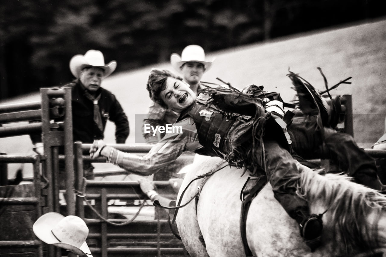 PORTRAIT OF HAPPY MAN RIDING HORSE ON FARM