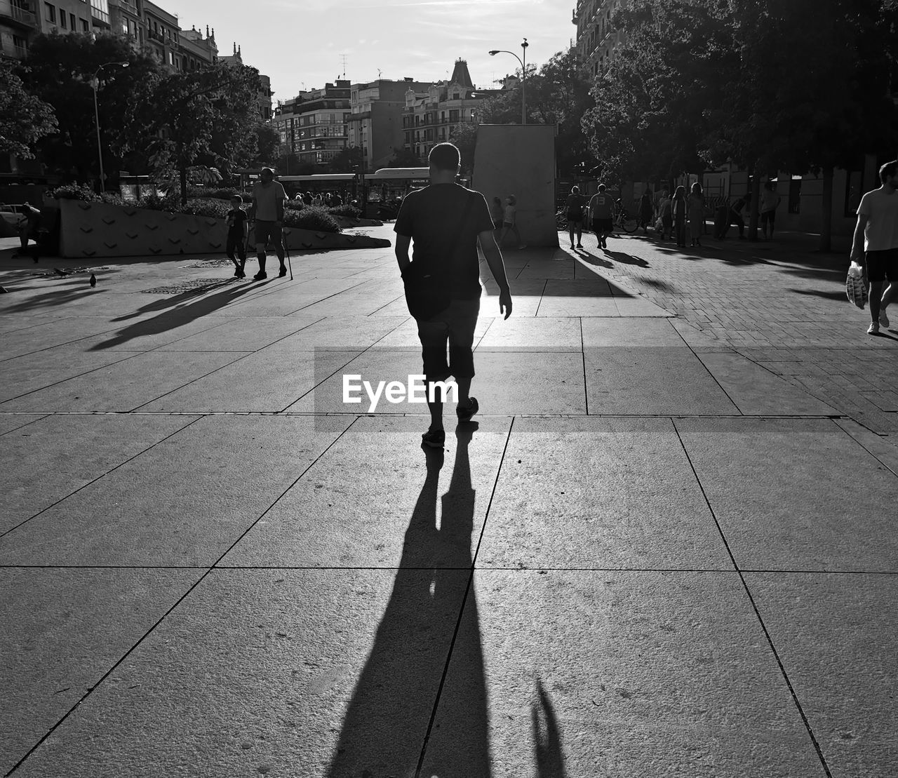 FULL LENGTH REAR VIEW OF MAN WALKING ON FOOTPATH