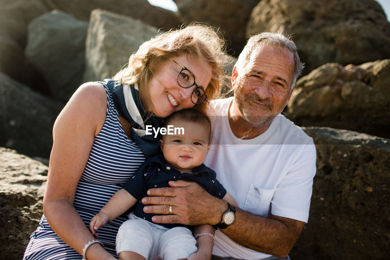 Grandparents holding & hugging grandson