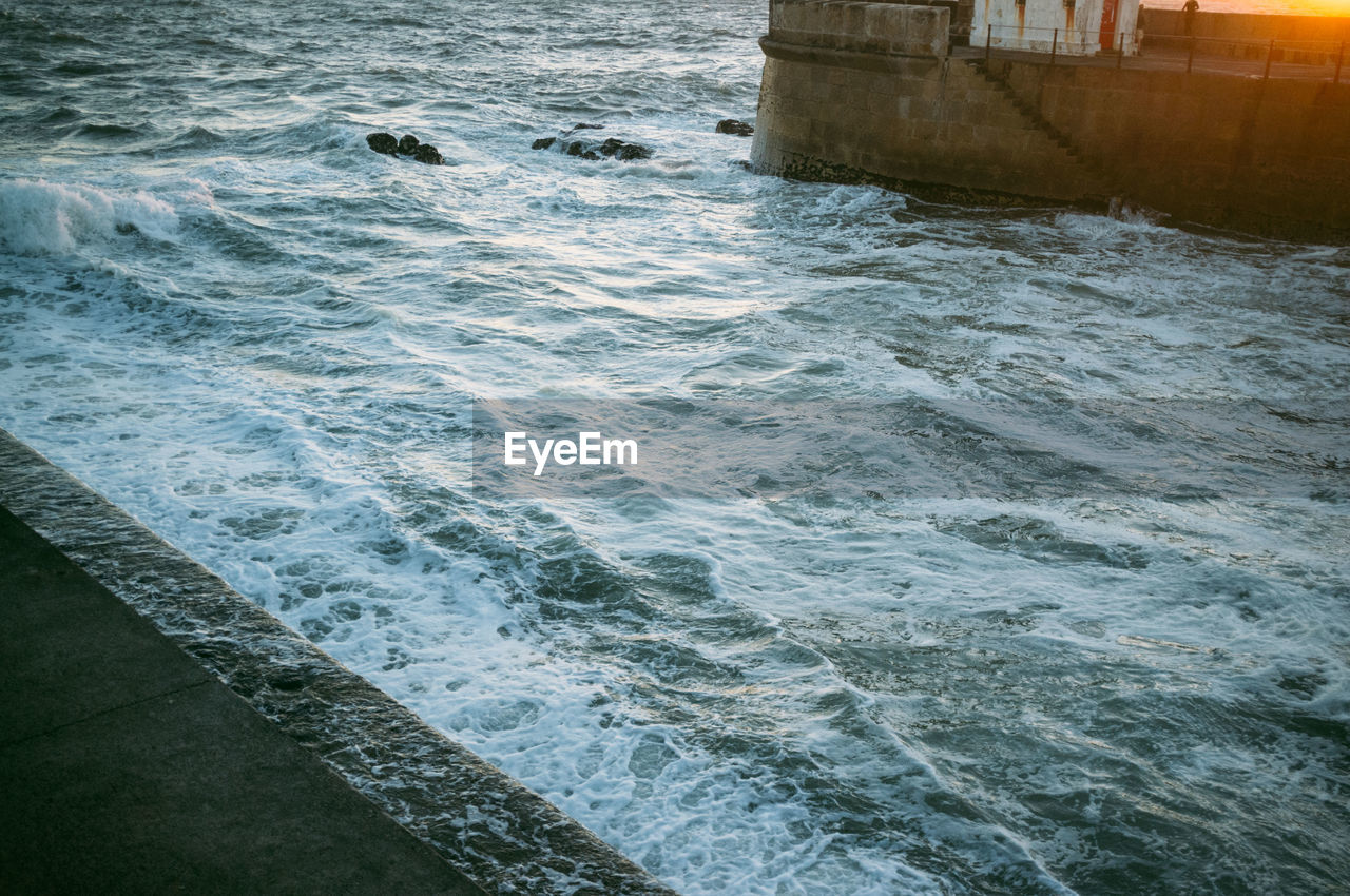 High angler view of waves in sea at harbor