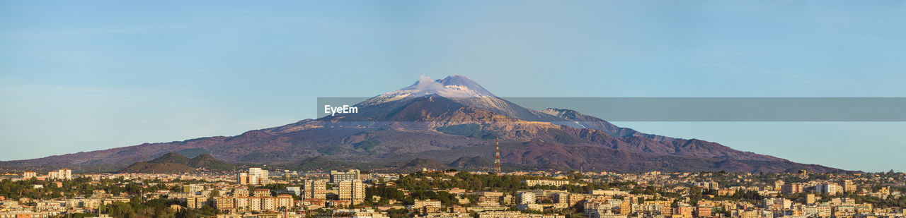 mountain, sky, landscape, nature, travel destinations, scenics - nature, volcano, land, environment, beauty in nature, no people, architecture, travel, outdoors, tourism, building exterior, day, mountain peak, city, blue, mountain range, plateau, built structure, clear sky, geology, panoramic