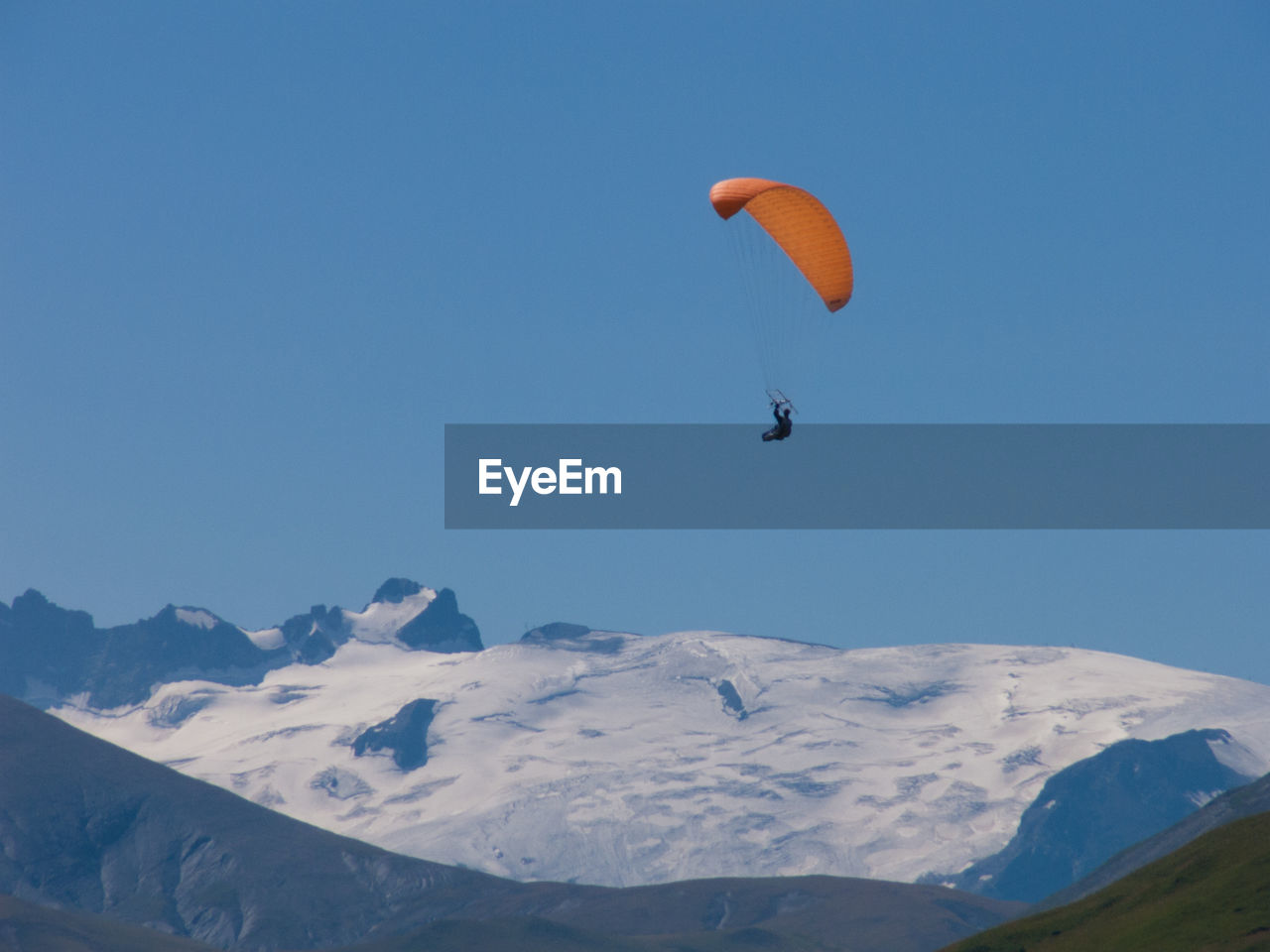 Low angle view of person paragliding against clear sky