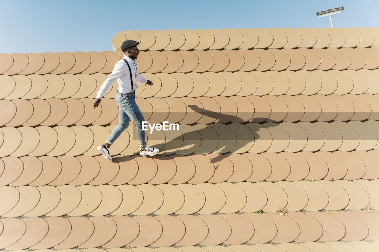 Young man walking on roofing tiles