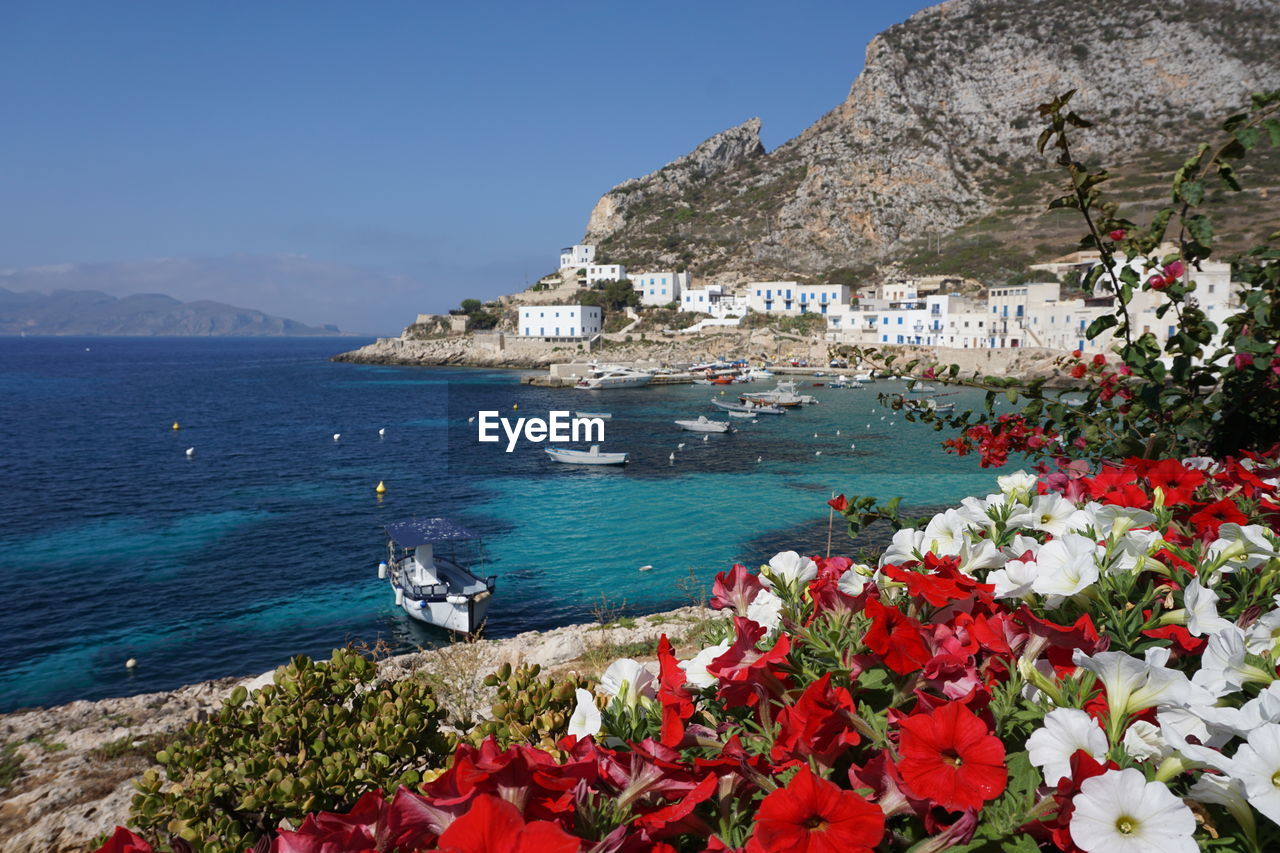 Scenic view of sea by mountains against sky