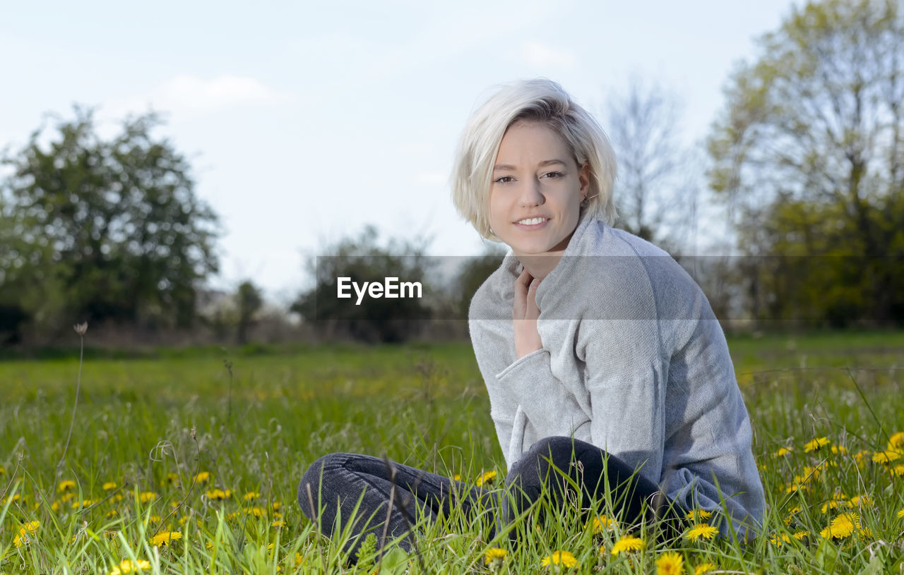 Portrait of young woman sitting on grass