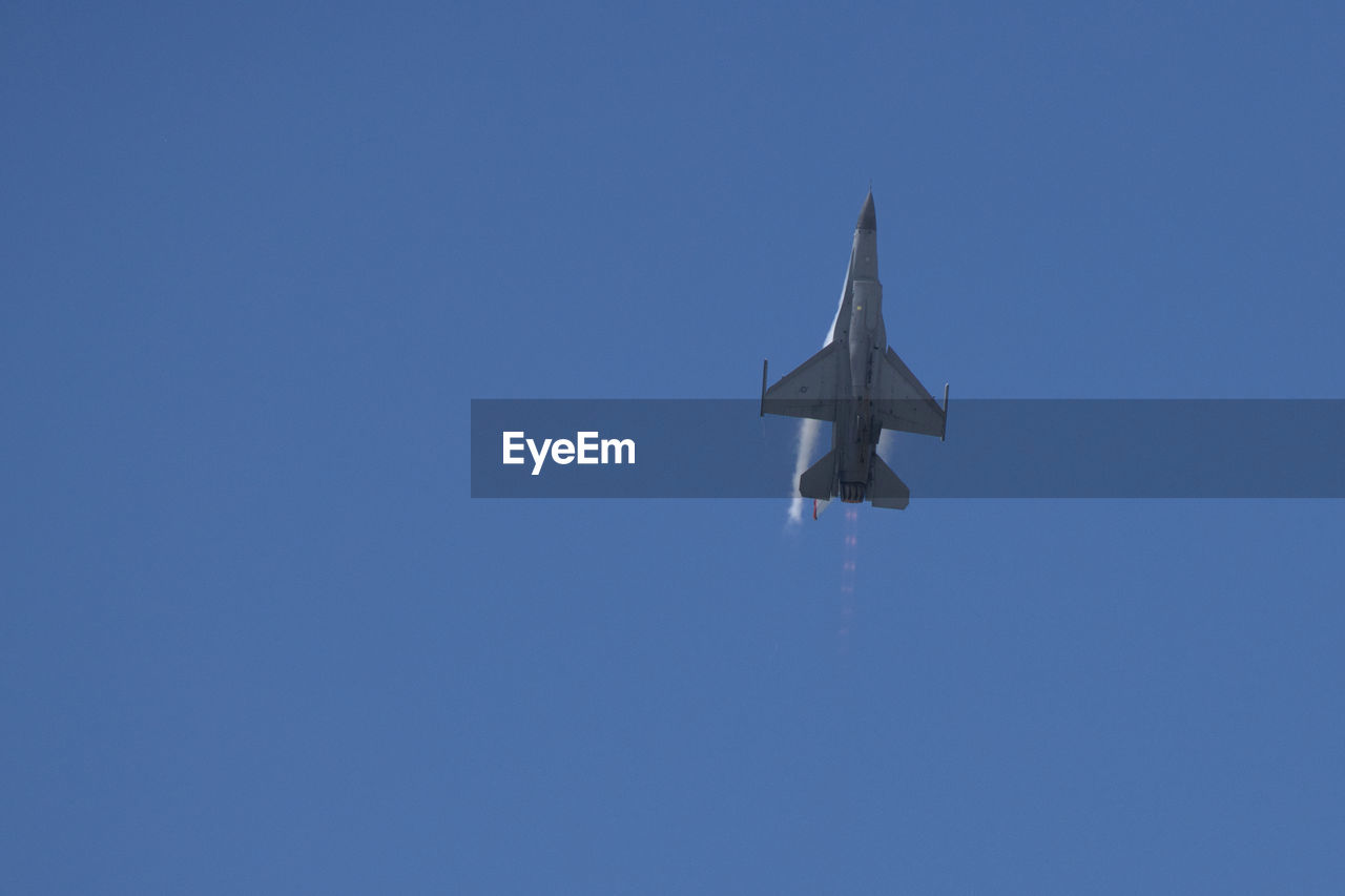 low angle view of airplane against clear blue sky