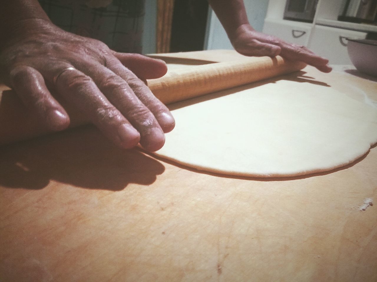 Cropped hands making dough on table