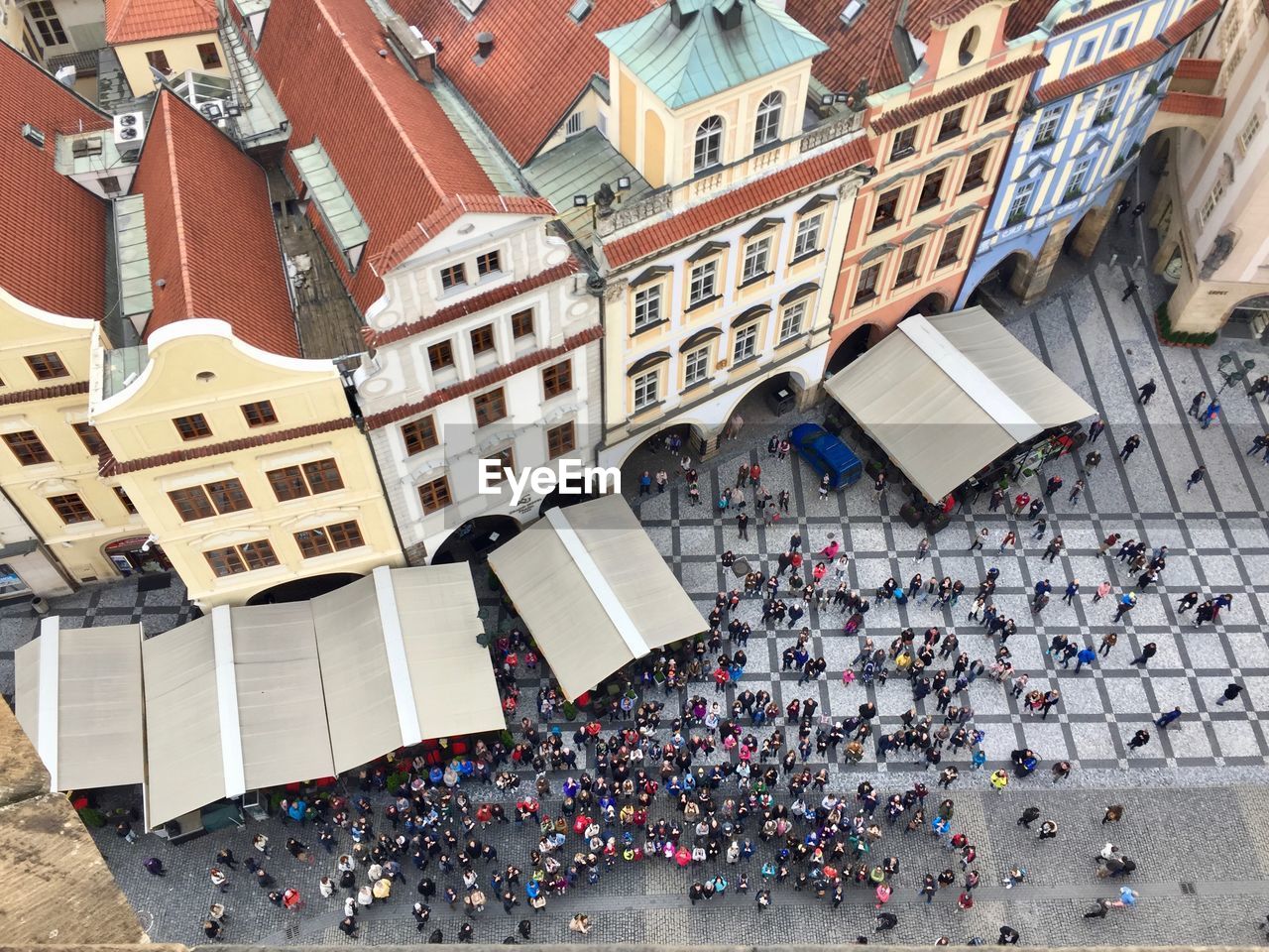 HIGH ANGLE VIEW OF CROWD ON STREET BY BUILDINGS