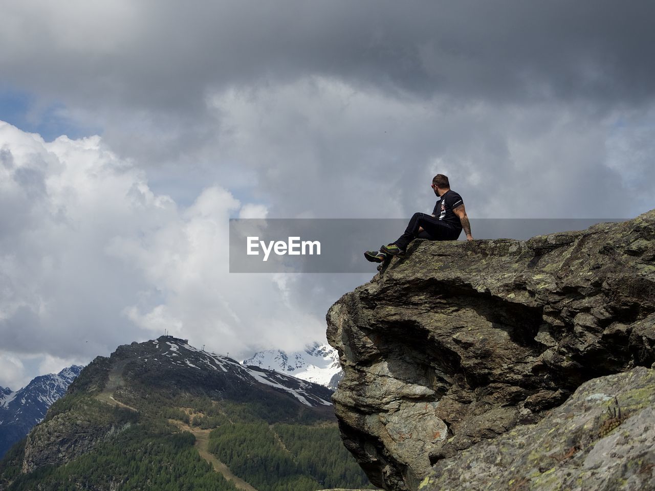REAR VIEW OF MAN STANDING ON ROCK
