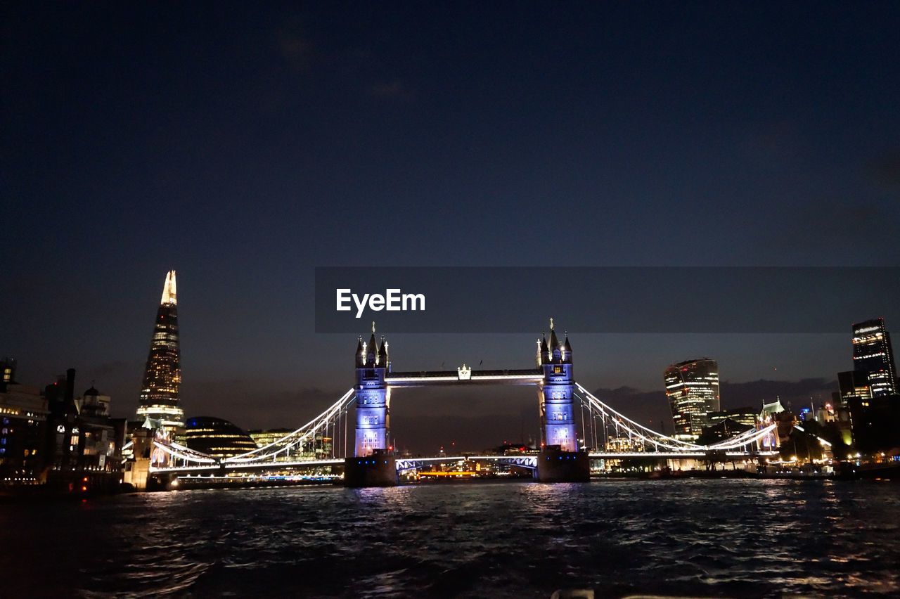 Suspension bridge over river at night