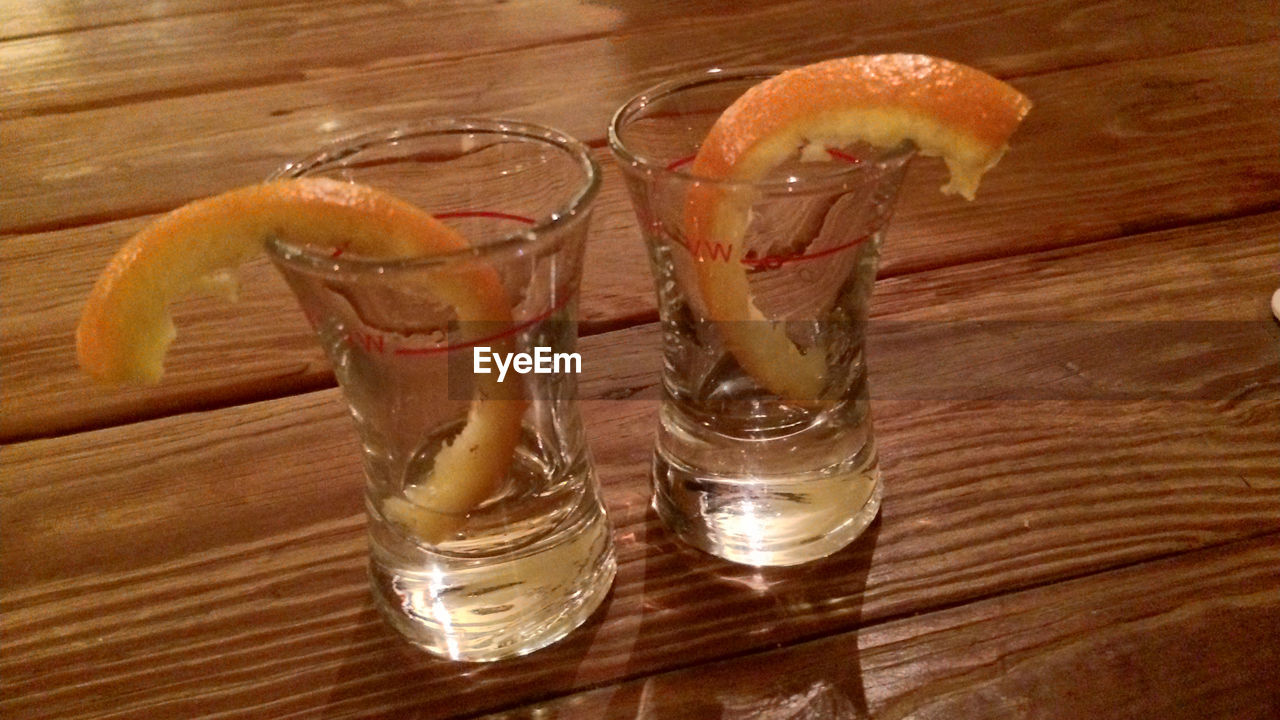 Tequila shot glasses on table with orange peel
