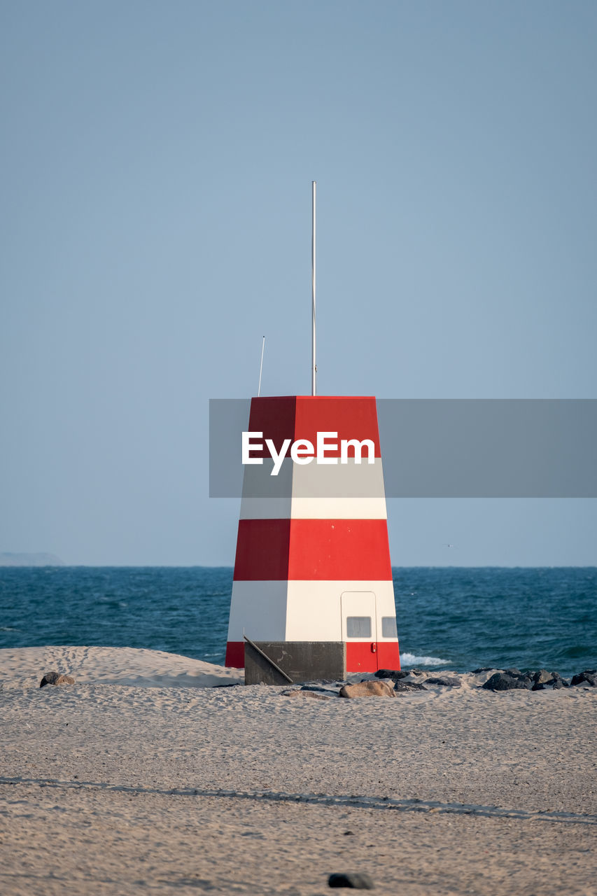 FLAG ON BEACH AGAINST SKY