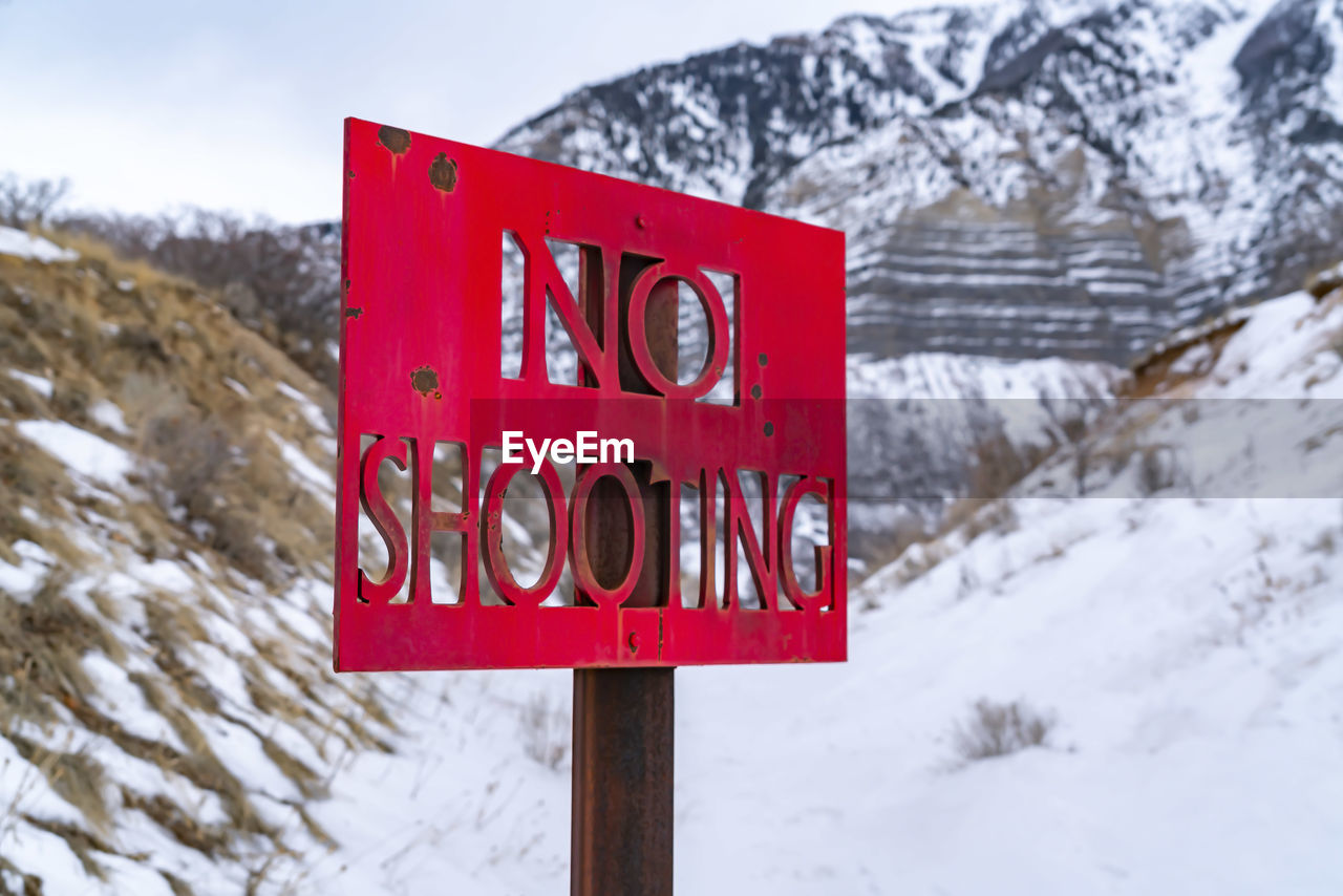 CLOSE-UP OF INFORMATION SIGN ON SNOW COVERED TREE