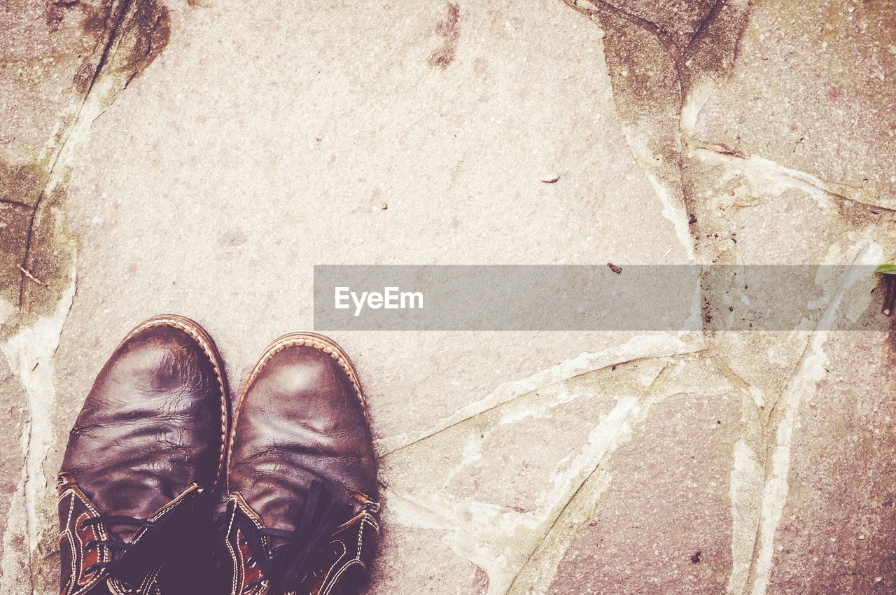 Directly above shot of old shoes on footpath