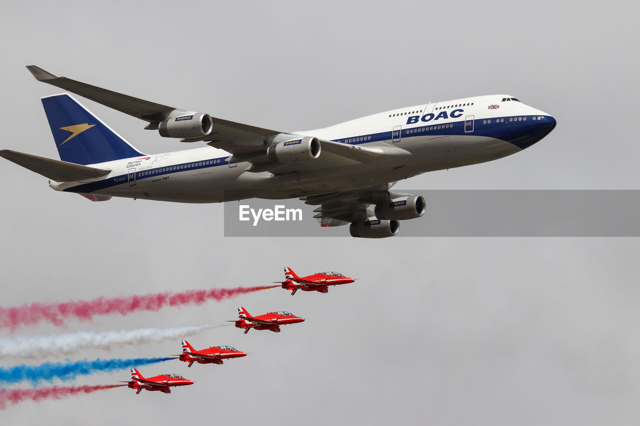 LOW ANGLE VIEW OF AIRSHOW IN MID-AIR AGAINST SKY