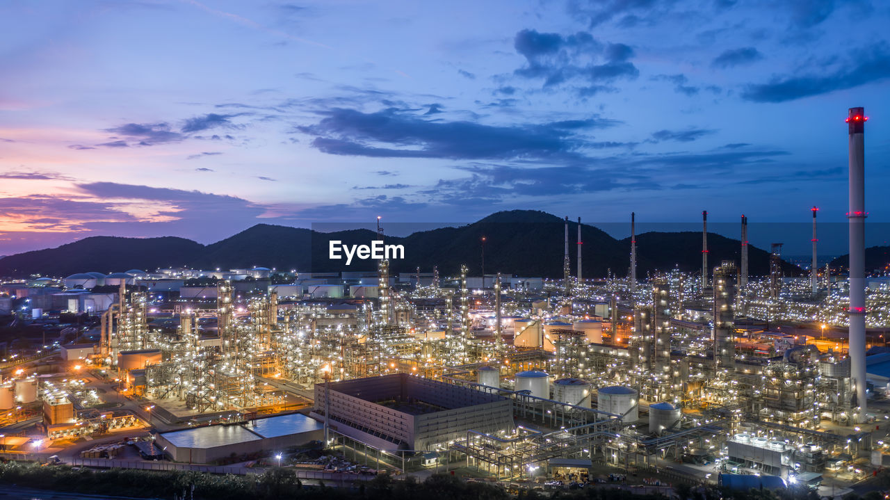 Aerial view oil and gas tank with oil refinery background at night, glitter lighting petrochemical.