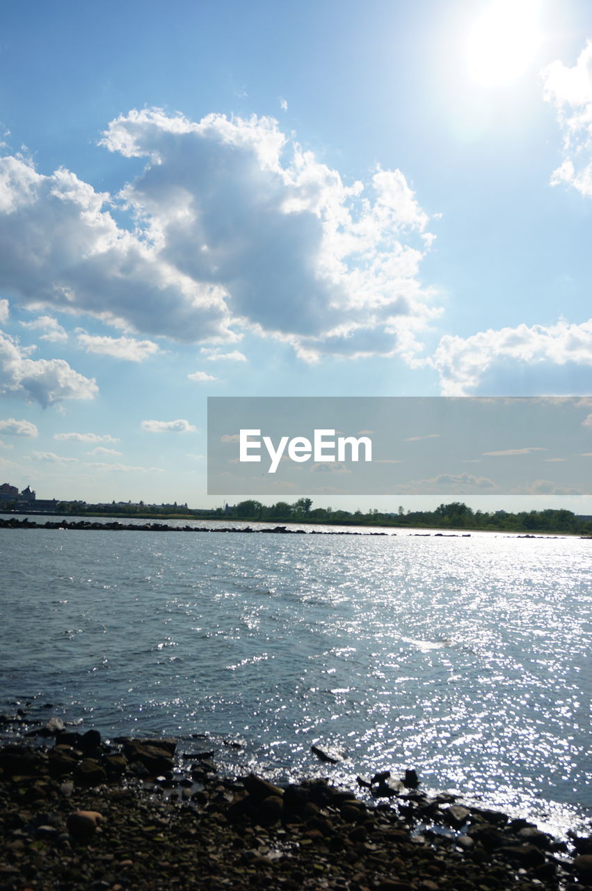 Scenic view of river against sky on sunny day