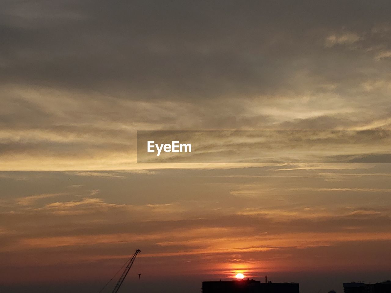 LOW ANGLE VIEW OF SILHOUETTE BUILDINGS AGAINST DRAMATIC SKY