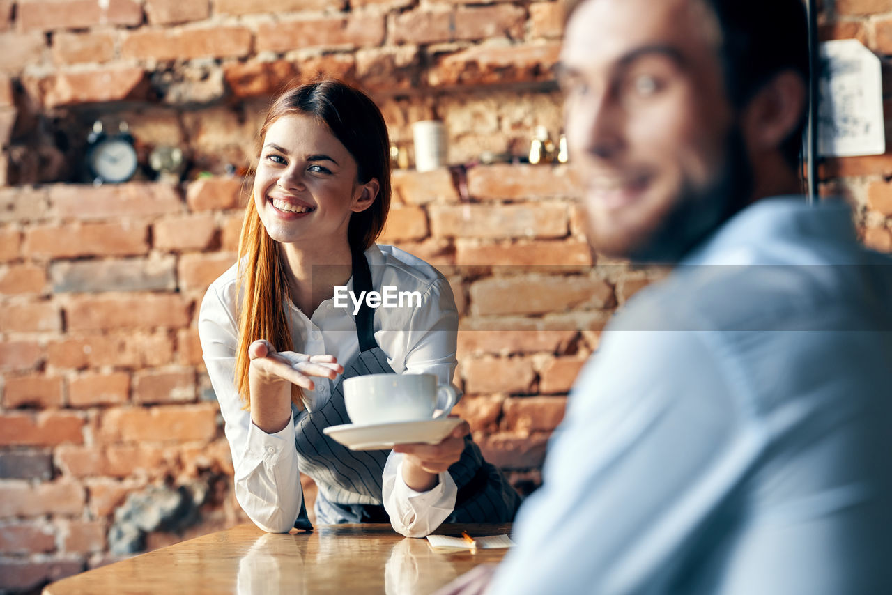 Portrait of smiling young woman holding drink