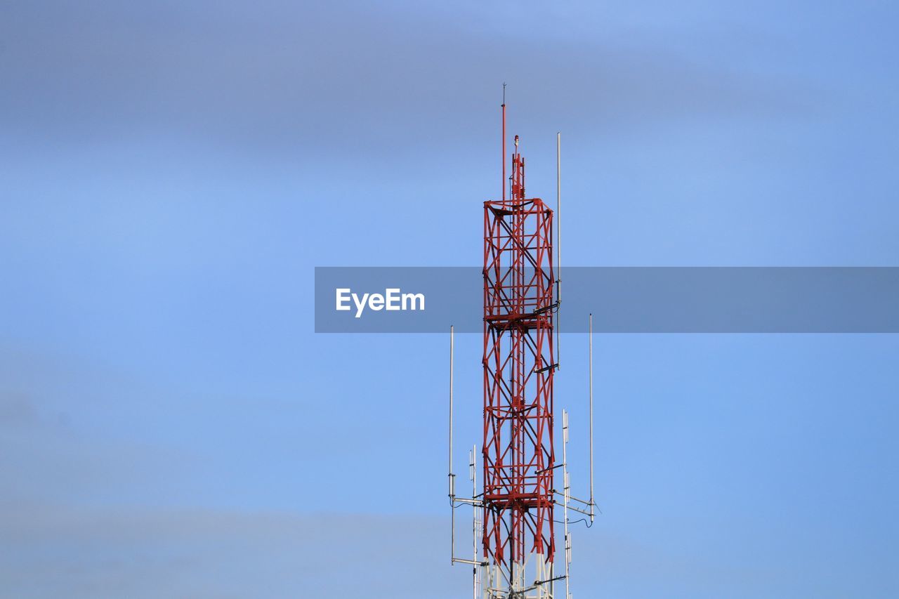 Low angle view of communications tower against blue sky