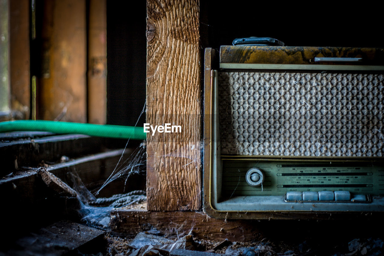 Close-up of old radio in abandoned shelf