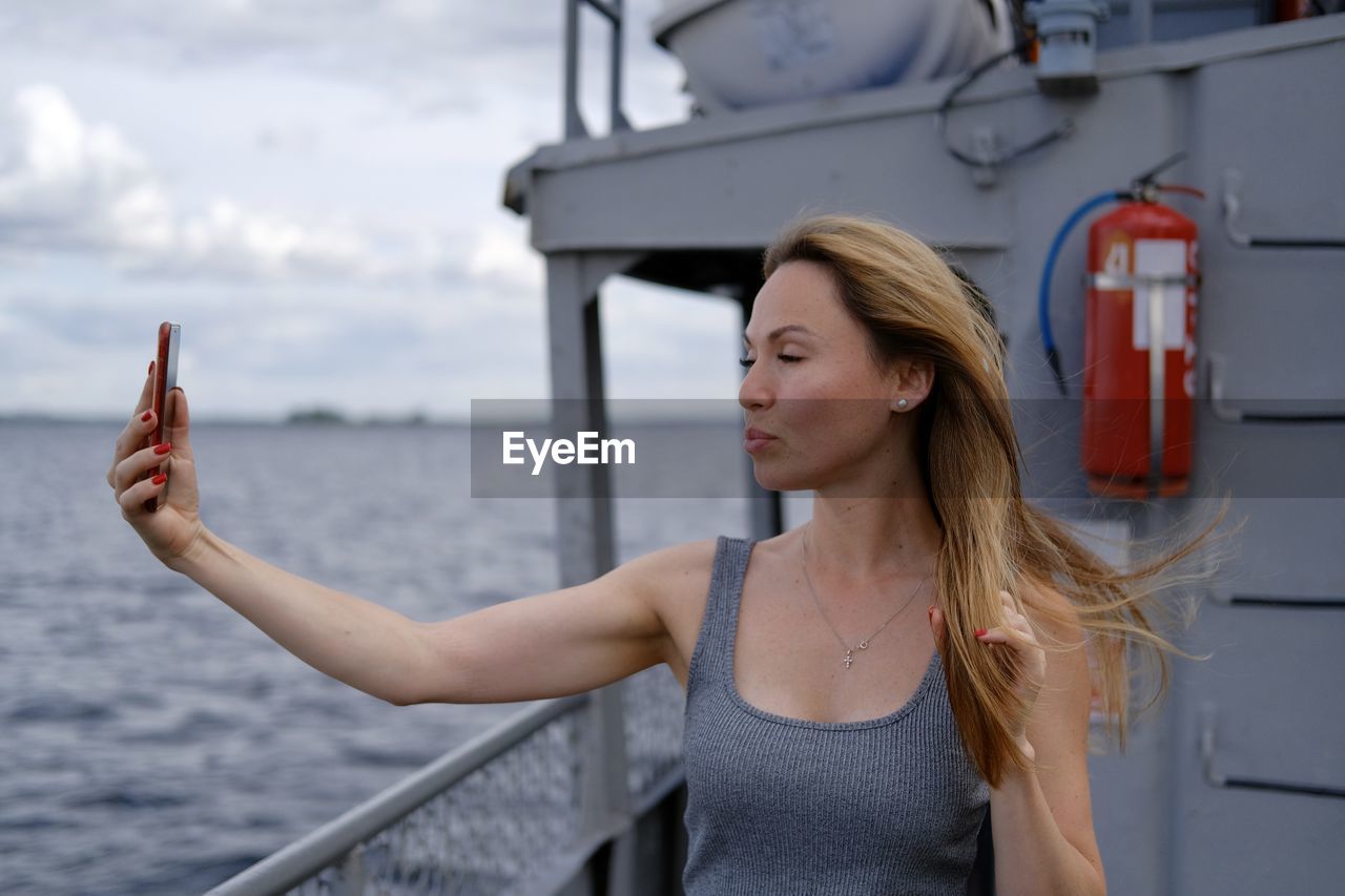 Beautiful white woman make selfie on a ferry boat 