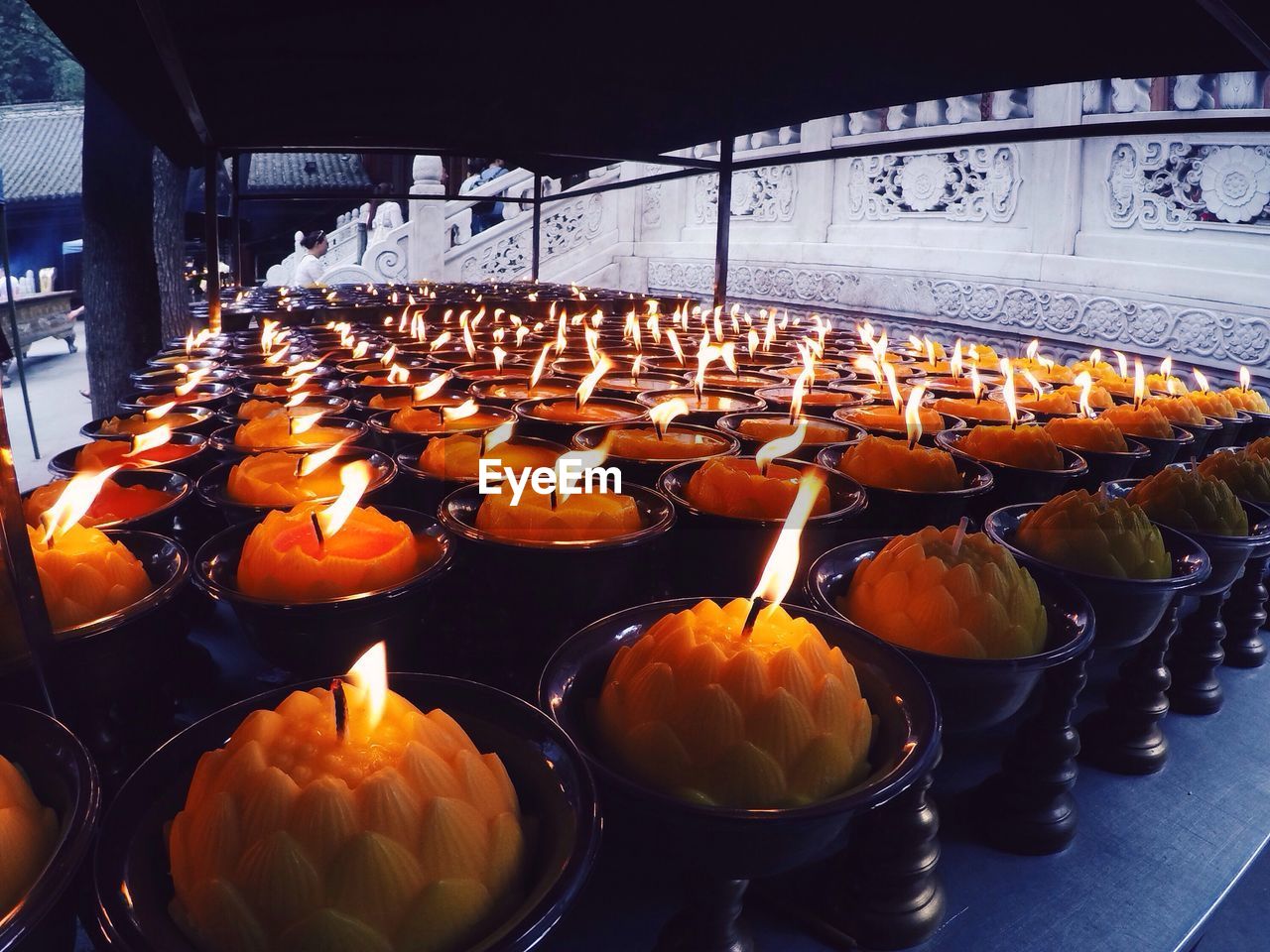 Close-up of lit candles in rows