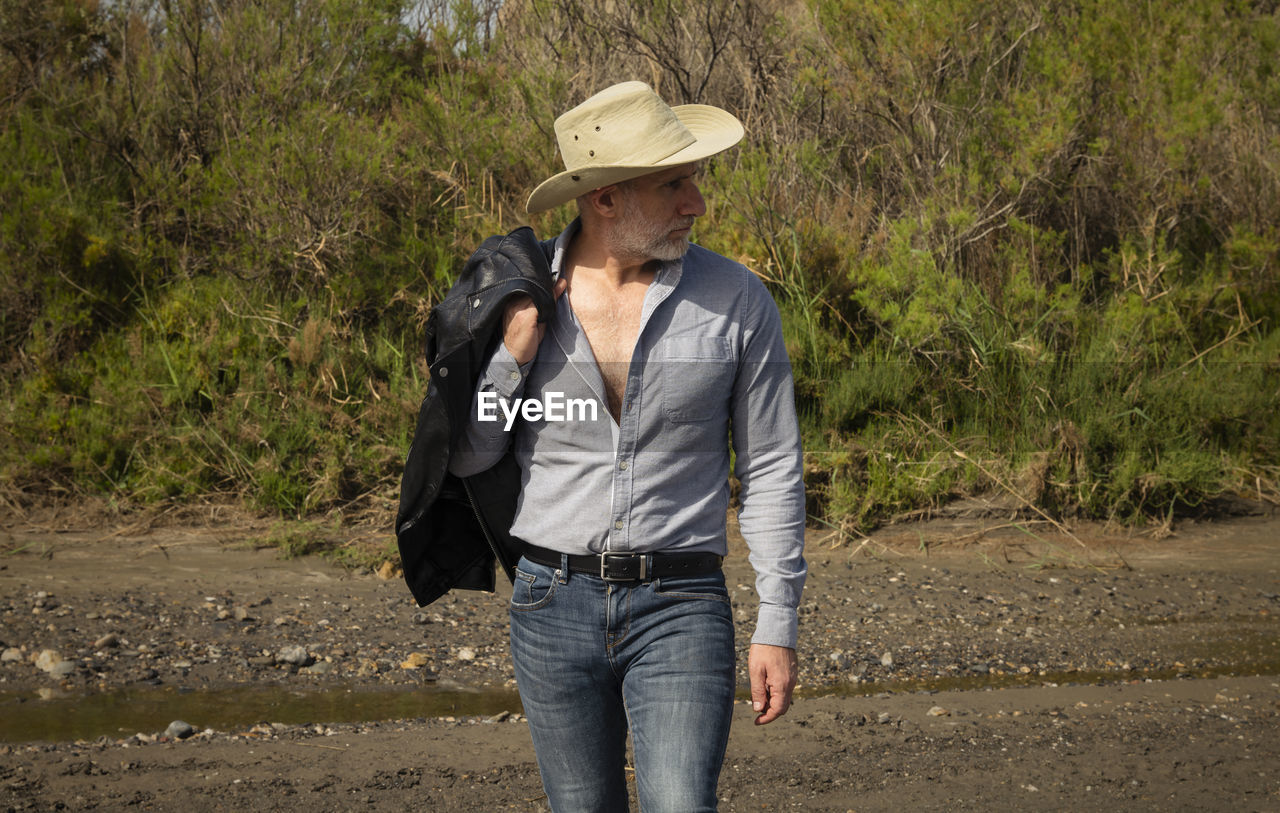 Adult man in cowboy hat in oasis of desert. almeria, spain