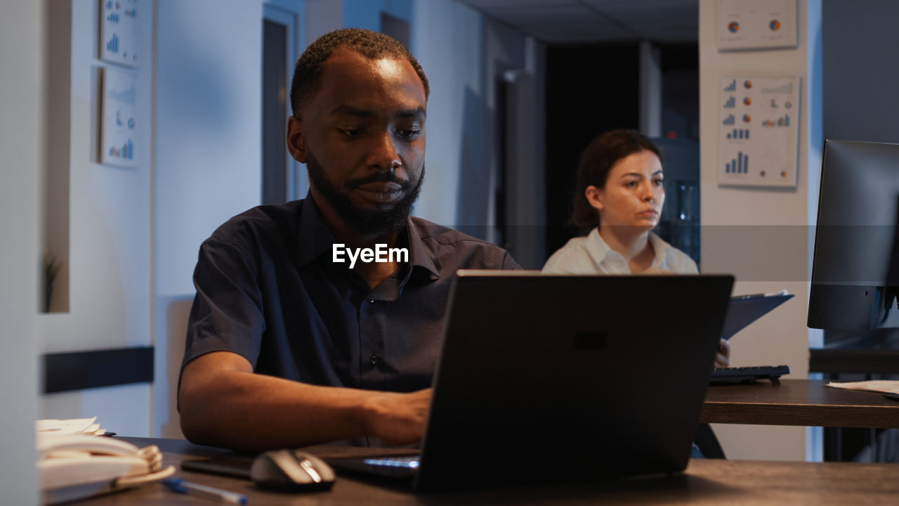 man using laptop while sitting at office