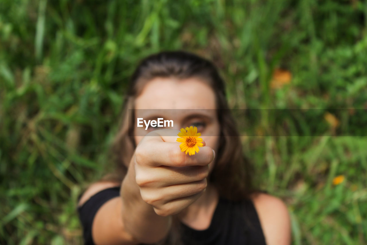 Portrait of woman holding yellow flower