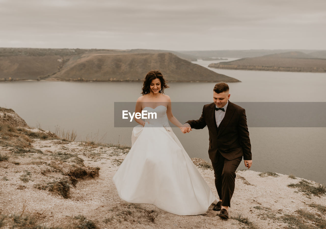 full length of bride standing on beach