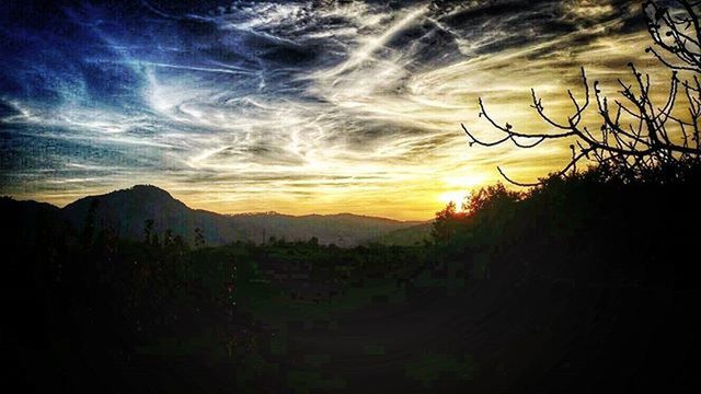 SCENIC VIEW OF MOUNTAINS AGAINST CLOUDY SKY AT SUNSET