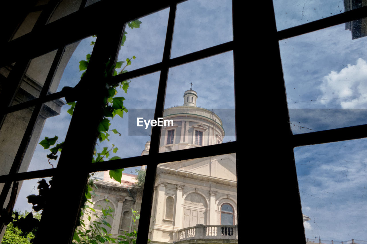 LOW ANGLE VIEW OF BUILDINGS SEEN THROUGH WINDOW