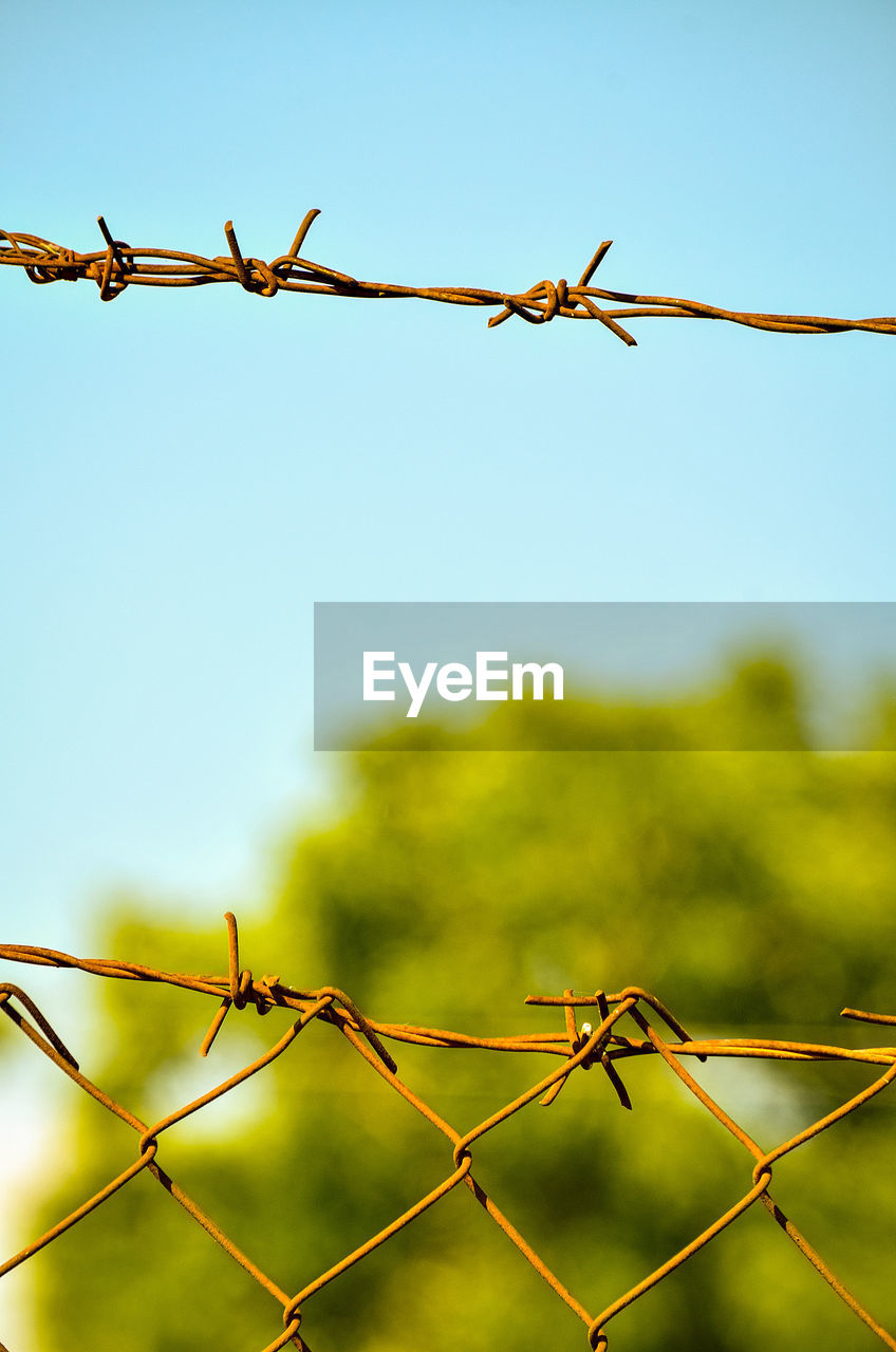 low angle view of barbed wire fence