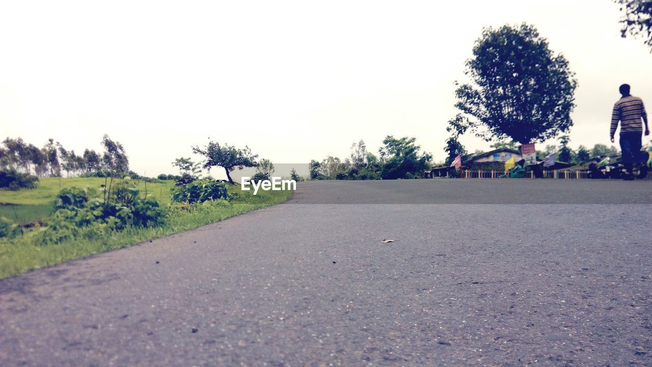 EMPTY ROAD WITH TREES IN BACKGROUND