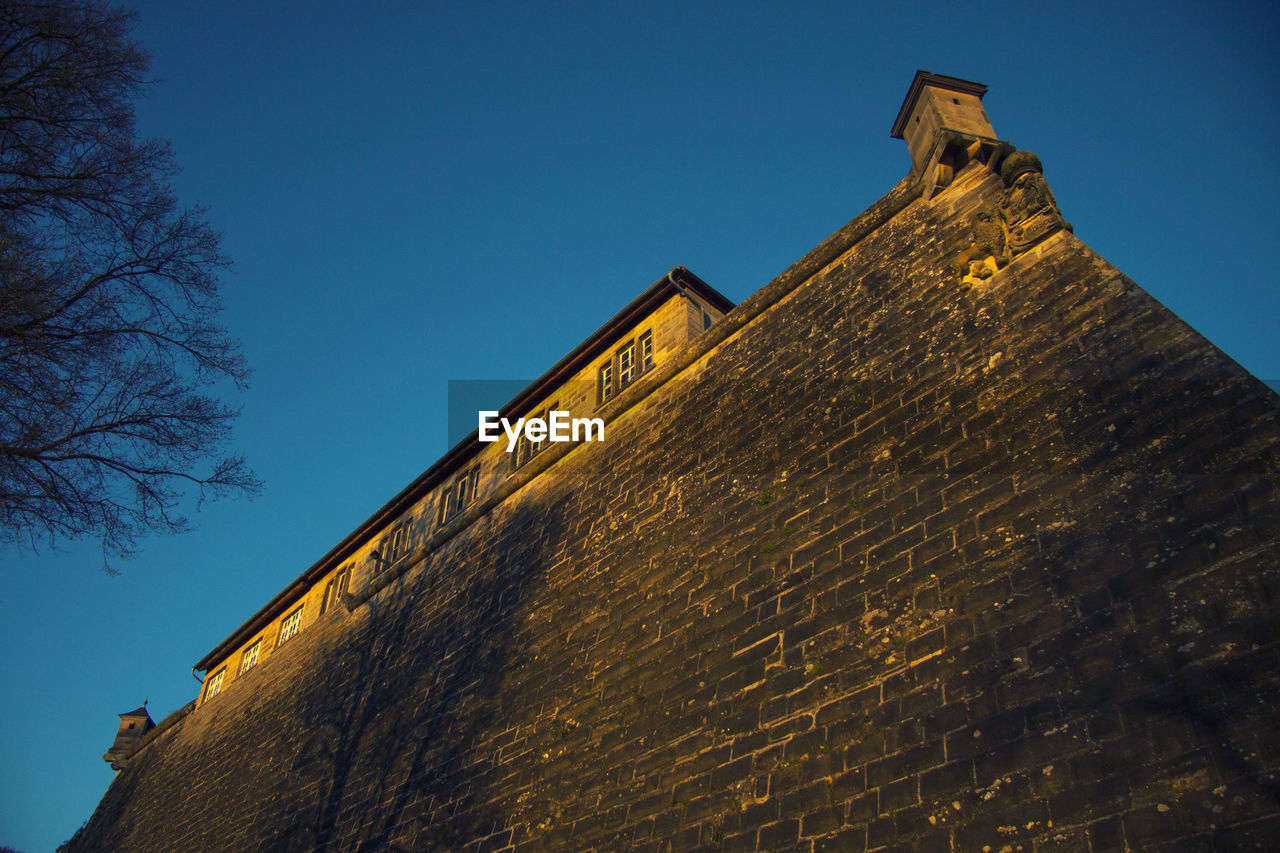 LOW ANGLE VIEW OF HISTORIC BUILDING AGAINST CLEAR BLUE SKY