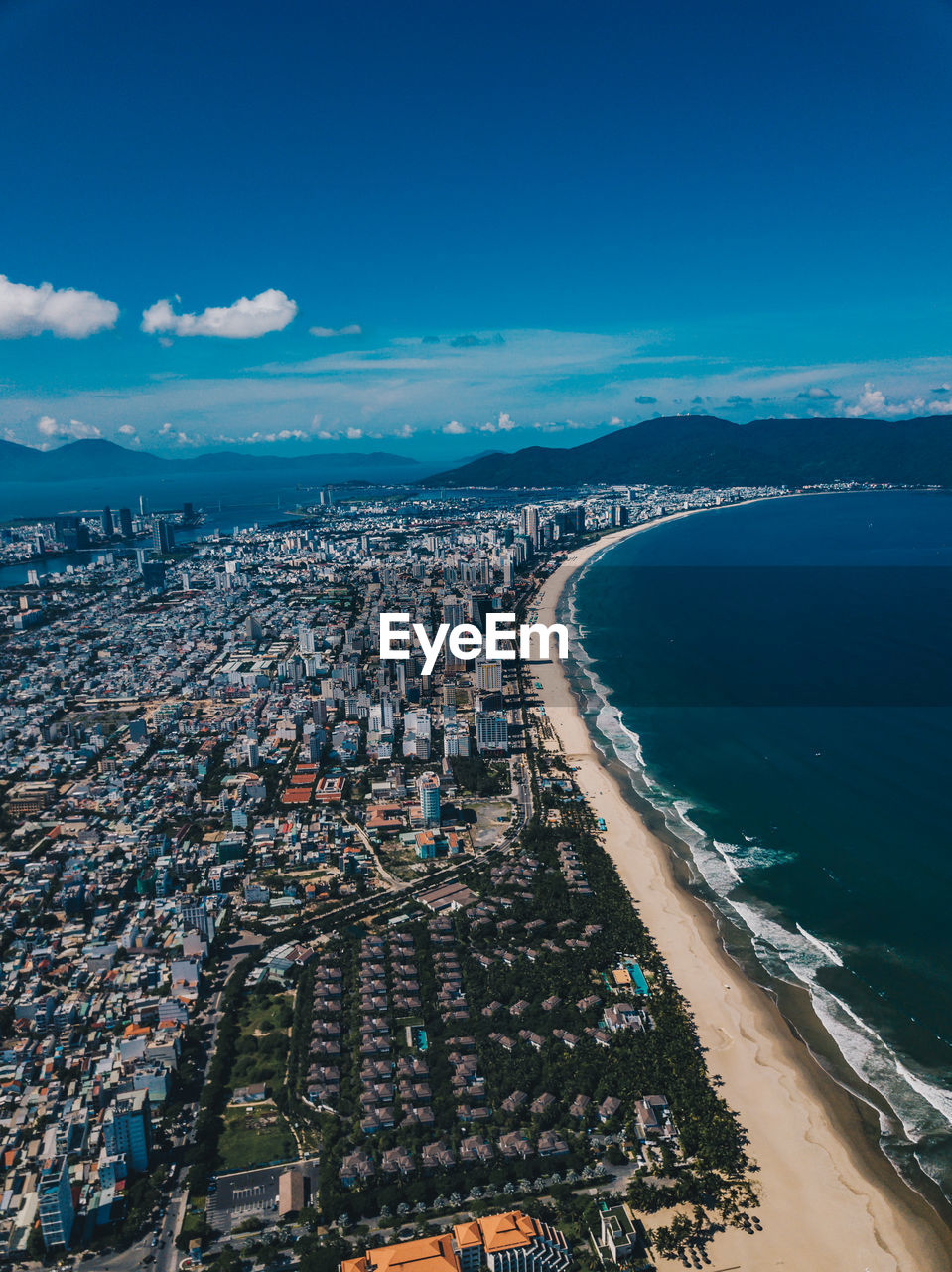Aerial view of sea and buildings against sky