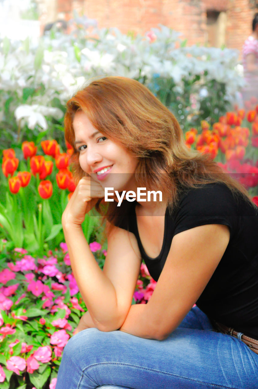 Portrait of beautiful woman sitting by plants