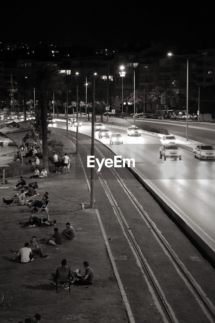 HIGH ANGLE VIEW OF PEOPLE ON ILLUMINATED STREET AT NIGHT