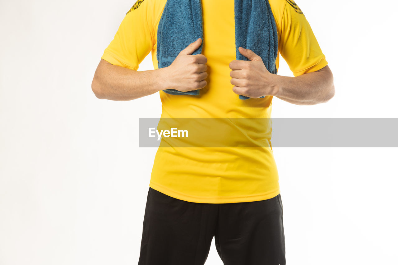 LOW SECTION OF MAN STANDING AGAINST YELLOW BACKGROUND