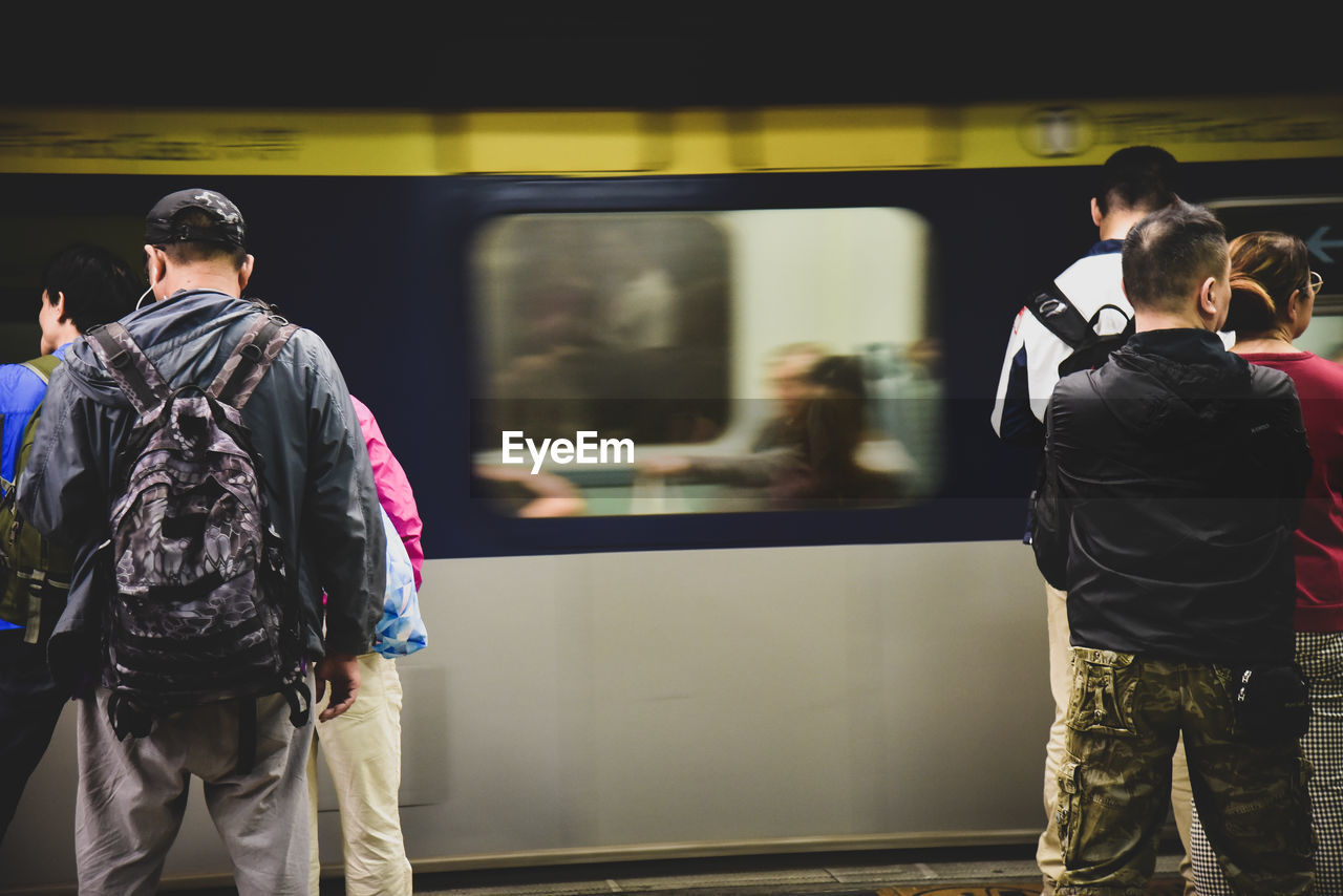 REAR VIEW OF PEOPLE AT RAILROAD STATION