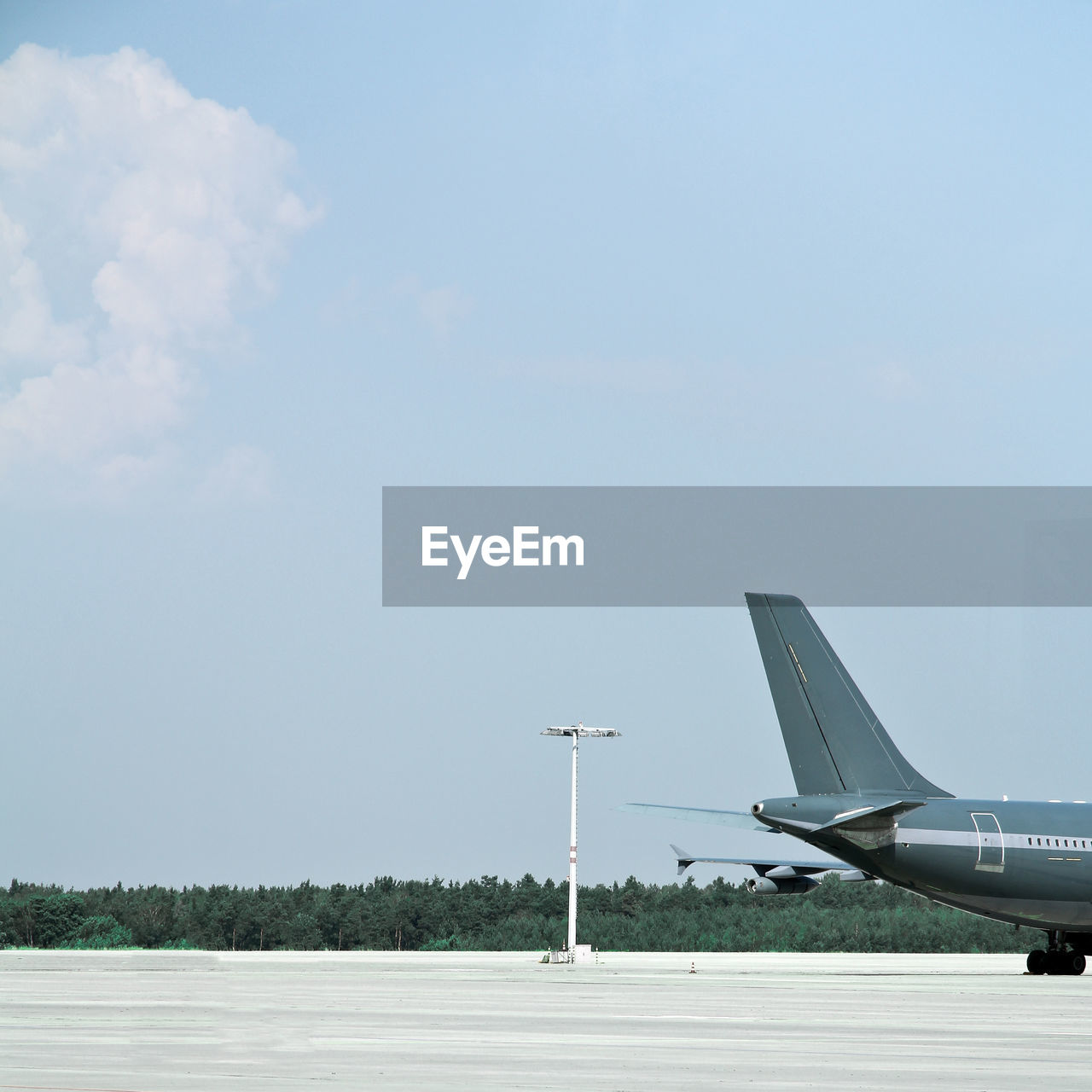 Airplane on airport runway against sky