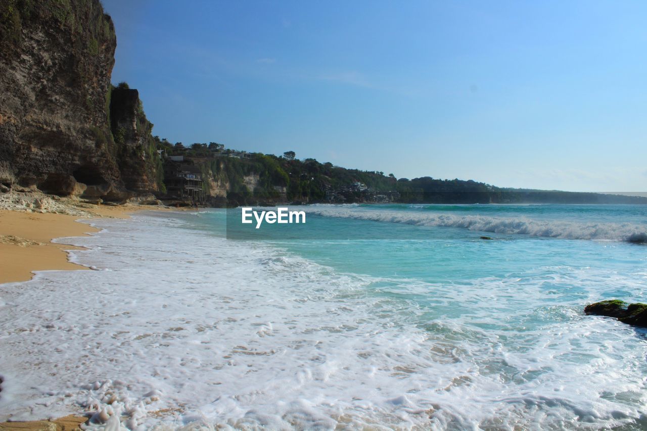 SCENIC VIEW OF ROCKY BEACH AGAINST SKY