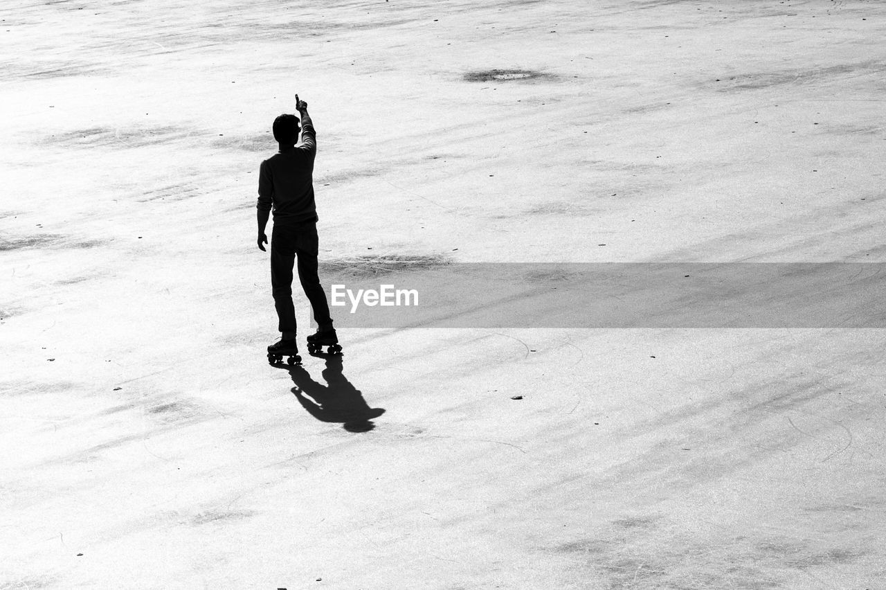 FULL LENGTH REAR VIEW OF MAN STANDING ON SNOW