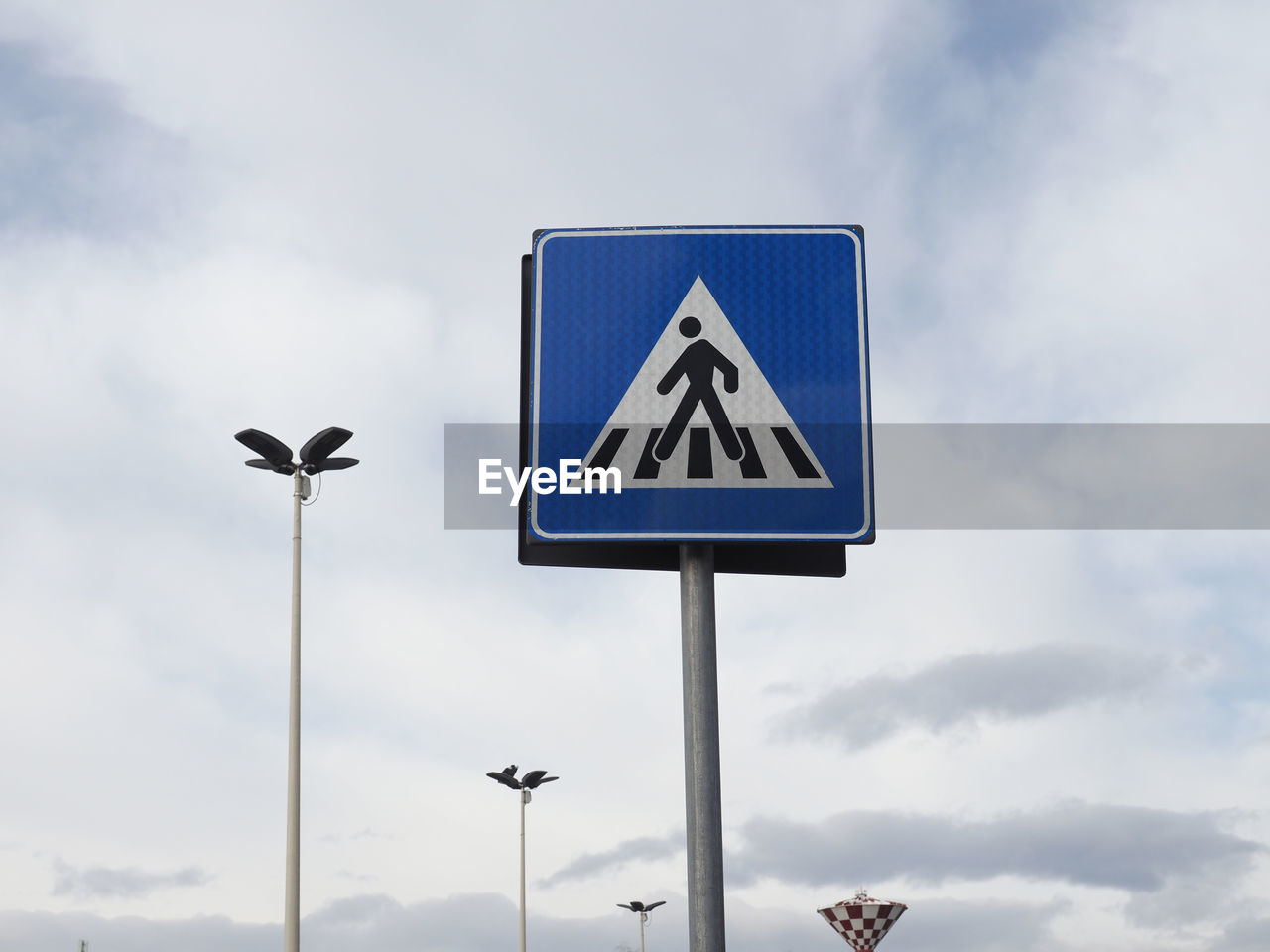 sign, cloud, sky, communication, road, road sign, guidance, street light, no people, nature, symbol, street sign, transportation, traffic sign, signage, lighting, light fixture, street, blue, day, warning sign, animal themes, animal, outdoors, arrow symbol, representation, city, triangle shape, directional sign, pole