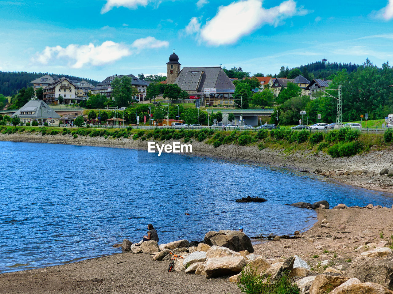 Scenic view of lake by buildings against sky