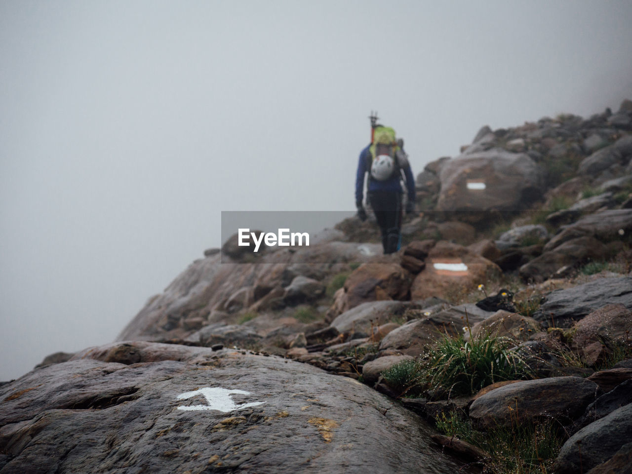 Markings on rocks with hiker in background