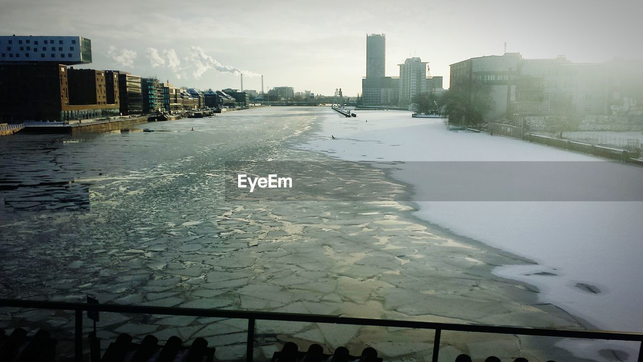 City buildings with frozen river