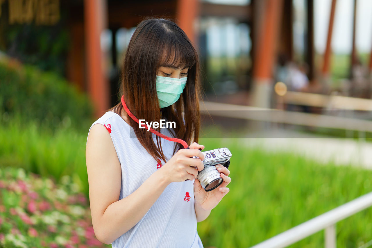 PORTRAIT OF WOMAN HOLDING CAMERA